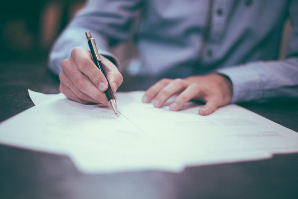 man-writing-on-paper-oqmzwnd3thu Sign here